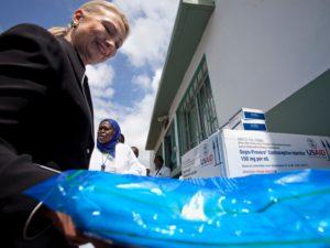 Then-U.S. Secretary of State Hillary Clinton picks up a mosquito net next to other medical supplies from the USAID program, including a box of Depo-Provera contraceptives, during a tour of the Philippe Senghor Health Center in Dakar August 1, 2012.